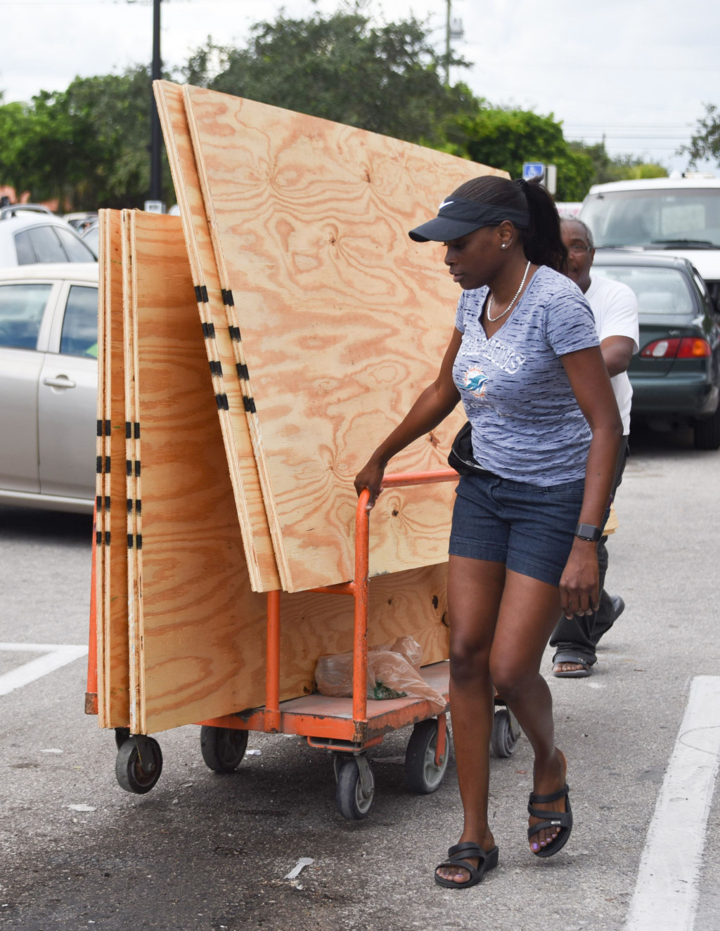 Seorang wanita memborong papan kayu untuk dijadikan benteng bagi rumahnya dari dampak kerusakan akibat badai. Kecepatan angin badai Irma diperkirakan bisa mencapai 280 kilometer per jam. AFP Photo/Michele Eve Sandberg