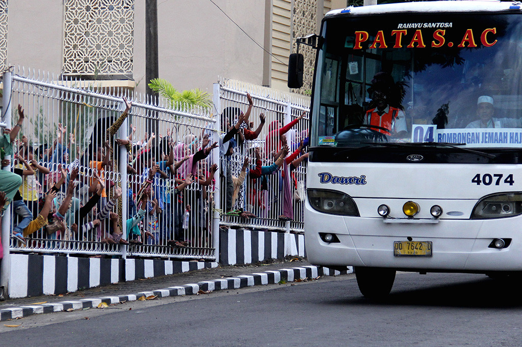 Sejumlah penjemput melambaikan tangan saat jamaah haji kloterpertama tiba di Asrama Haji Sudiang, Makassar, Sulawesi Selatan, Kamis (7/9/2017). Sebanyak 454 haji ditambah seorang haji yang meninggal dalam perjalanan kloter pertama debarkasi Makassar tiba setelah usai menunaikan ibadah haji. ANTARA/Abriawan Abhe
