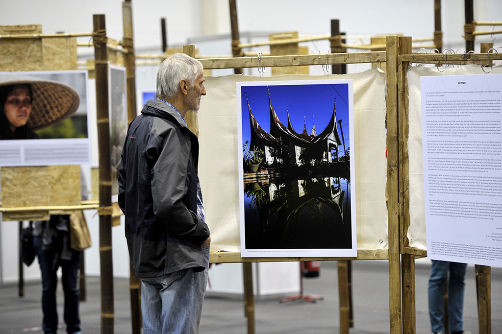 Pengunjung mengamati foto yang dipamerkan dalam Pameran Foto Mutter (Ibu) pada ajang festival budaya Indonesia, Pasar Hamburg 2017, di Hamburg Messehalle, Hamburg, Jerman.