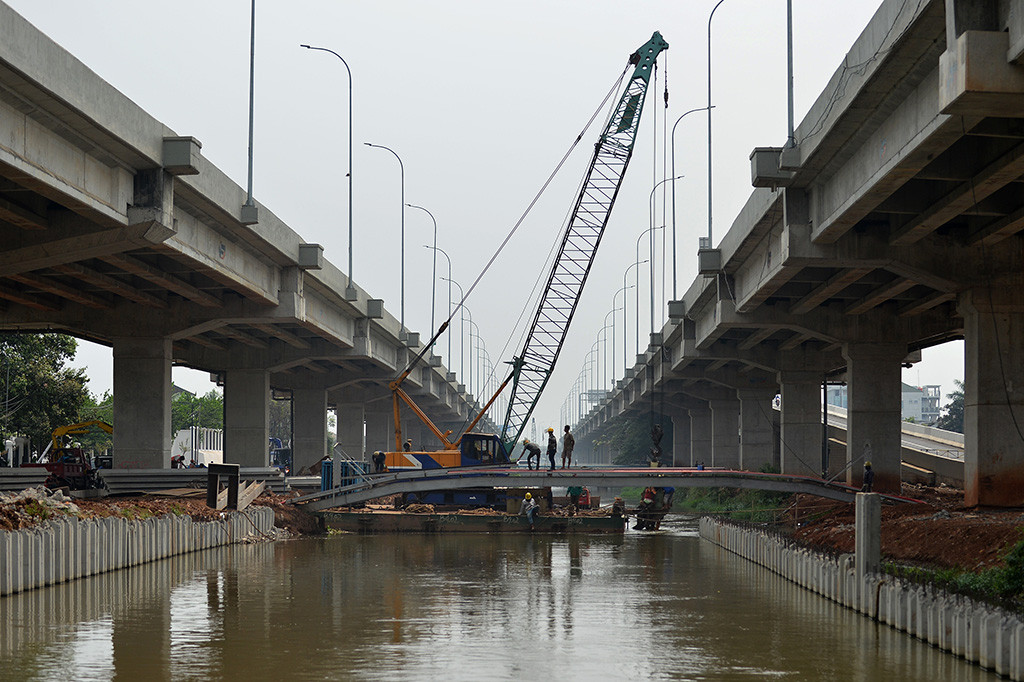 Pekerja membangun jembatan diantara tol Becakayu di atas sungai Kalimalang, Jakarta.