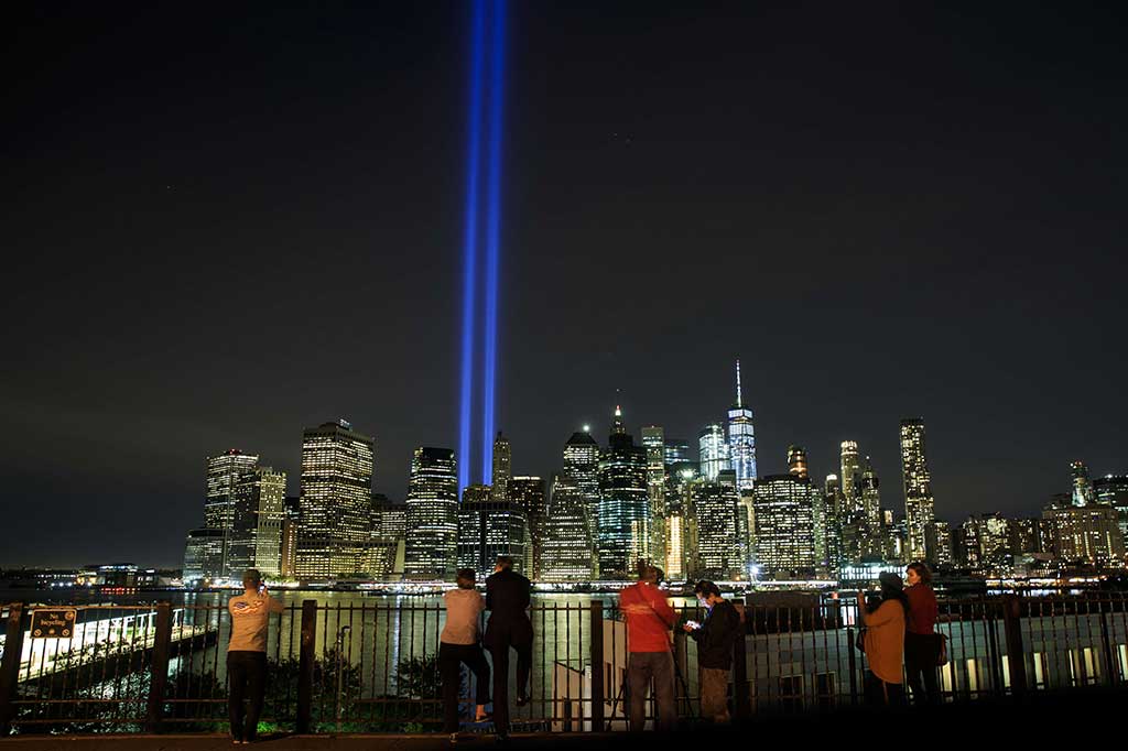 Warga menikmati sorotan cahaya kembar  berwarna biru 'Tribute in Light' untuk mengenang tragedi serangan WTC, di New York, AS, Senin (11/9/2017).