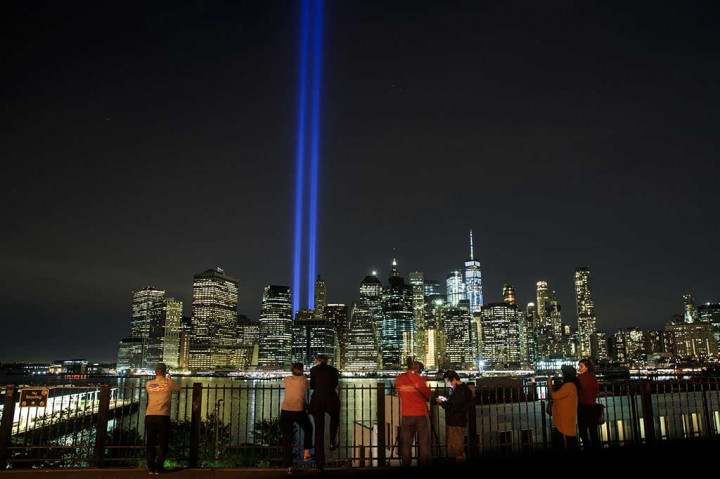 Warga menikmati sorotan cahaya kembar  berwarna biru 'Tribute in Light' untuk mengenang tragedi serangan WTC, di New York, AS, Senin (11/9/2017).