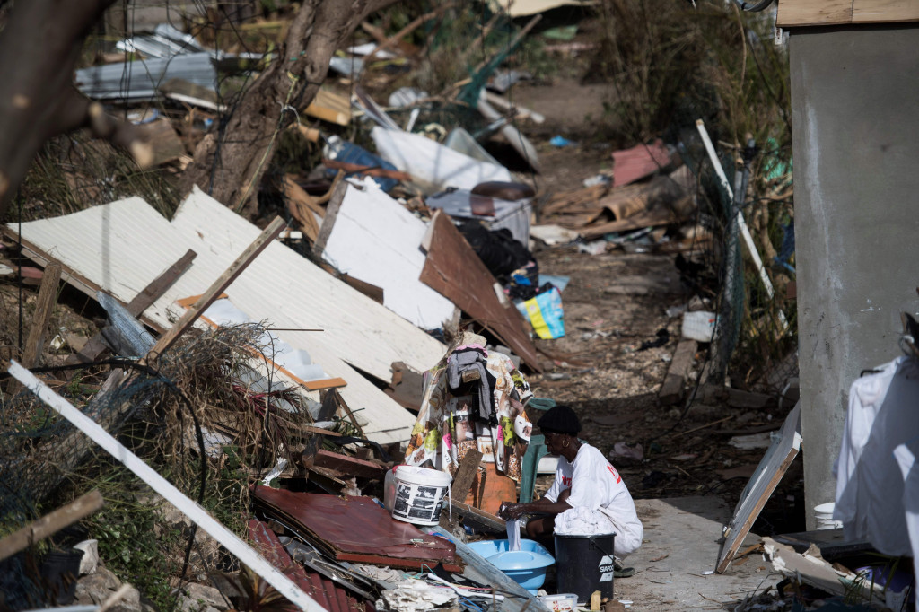 Seorang warga lokal mencuci pakaian di antara reruntuhan pemukiman tempat tinggalnya di Pulau Saint-Martin, French Caribbean. AFP Photo/Martin Bureu
