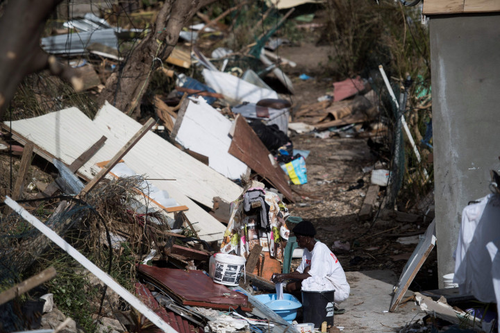 Seorang warga lokal mencuci pakaian di antara reruntuhan pemukiman tempat tinggalnya di Pulau Saint-Martin, French Caribbean. AFP Photo/Martin Bureu