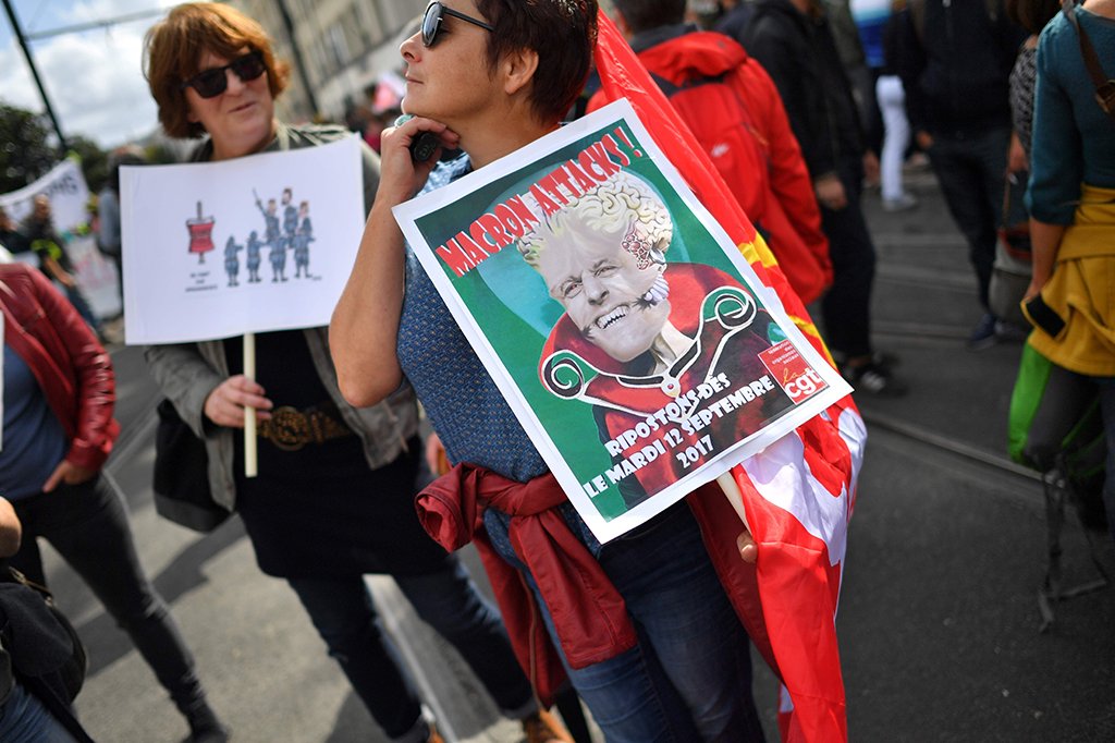 Seorang demonstran memegang poster bertuliskan 