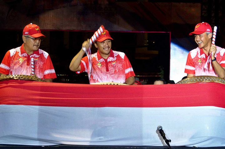 Menpora Imam Nahrawi (tengah) bersama Gubernur Jateng Ganjar Pranowo (kanan) dan Sekda Jateng Sri Puryono memukul perkusi sebagai tanda pembukaan Pekan Olahraga Pelajar Nasional (Popnas) XIV, di Semarang, Jawa Tengah, Selasa (12/9/2017) malam.