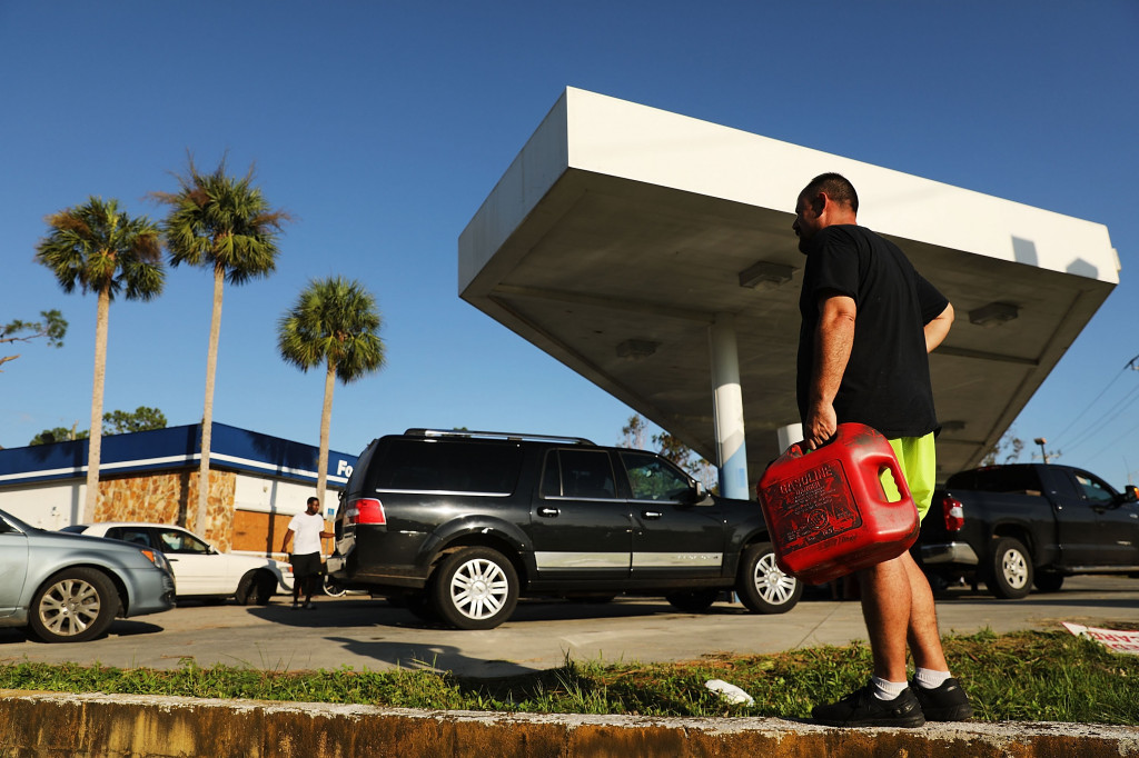 Seorang warga ikut antri bersama ratusan mobil di sebuah SPBU di pinggiran Naplles, Florida. Terputusnya akses jalan dan aliran listrik menyebabkan krisis bahan bakar. Spencer Platt/Getty Images/AFP