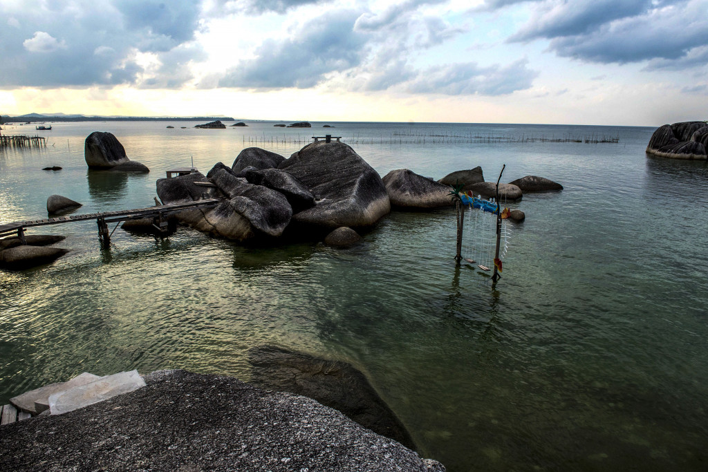 Di sekitar bibir pantai timur terhampar batu-batuan besar yang kokoh menghadap laut.
