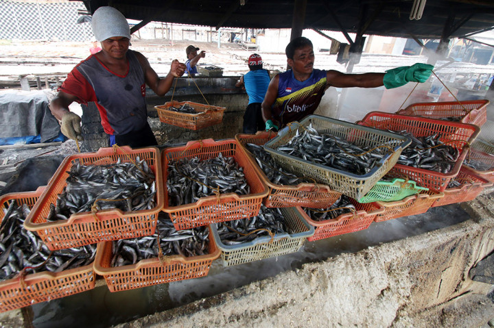 Warga memasak ikan asin secara tradisional di Muara Angke, Jakarta.