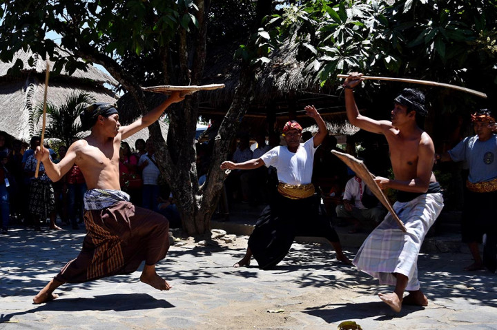 Warga bertarung dengan menggunakan rotan penjalin dan tameng ende dalam tradisi budaya Peresean di Kampung Adat Sasak Sade, Desa Rambitan, Pujut, Lobok Tengah, Nusa Tenggara Barat (NTB).