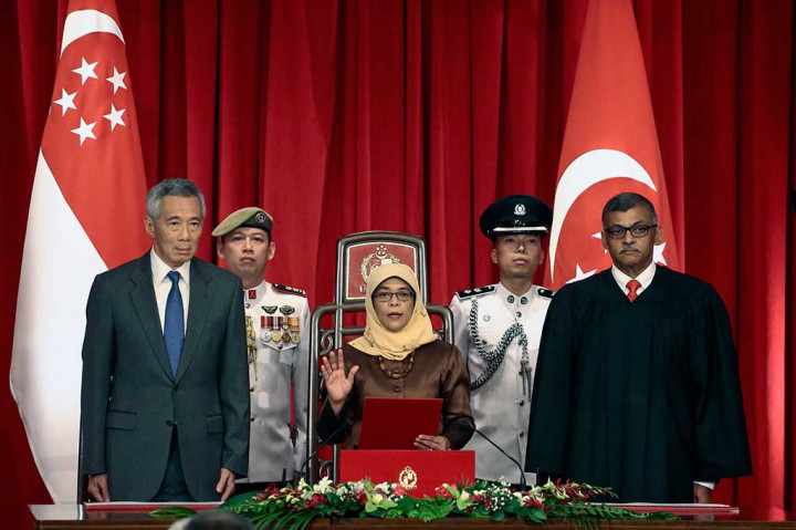 Presiden terpilih Singapura Halimah Yacob, didampingi Perdana Menteri Lee Hsien Loong (kiri) dan Ketua Mahkamah Agung Sundaresh Menon mengucapkan sumpah saat upacara pelantikan di Istana Kepresidenan Singapura, Kamis (14/9/2017).