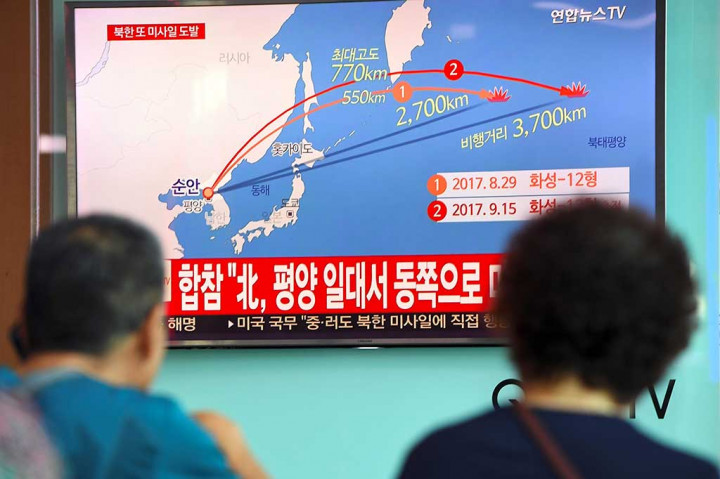 Warga menonton siaran televisi yang melaporkan pelunduran rudal Korea Utara, di sebuah stasiun kereta api di Seoul, Korsel, Jumat (15/9/2017).