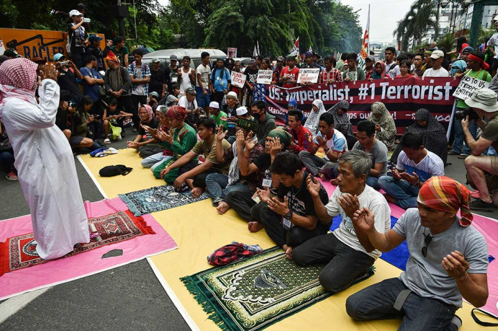 Warga Muslim berdoa bersama saat melakukan demonstrasi di depan Kedubes AS di Manila. 