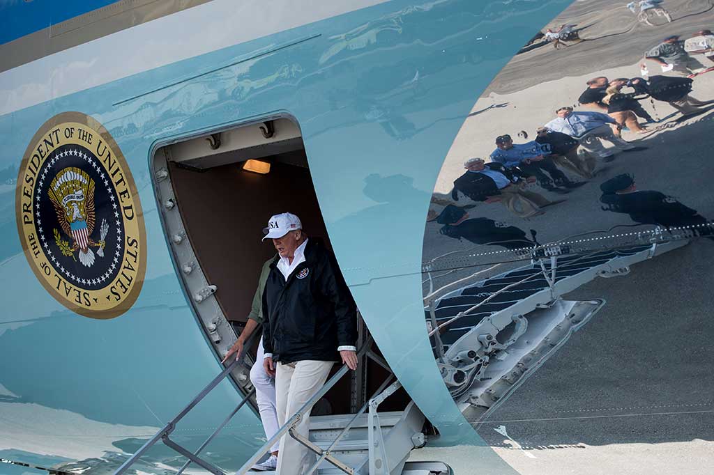 Presiden AS Donald Trump bersama Melania Trump menuruni tangga pesawat saat tiba di Bandara Internasional Florida, Kamis (14/9/2017) waktu setempat.