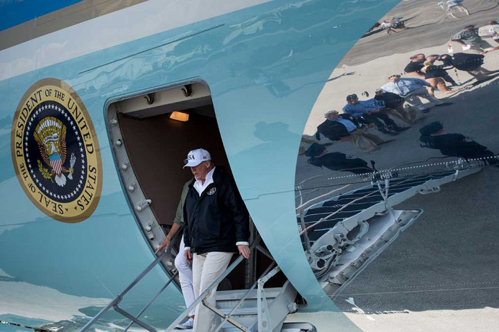 Presiden AS Donald Trump bersama Melania Trump menuruni tangga pesawat saat tiba di Bandara Internasional Florida, Kamis (14/9/2017) waktu setempat.