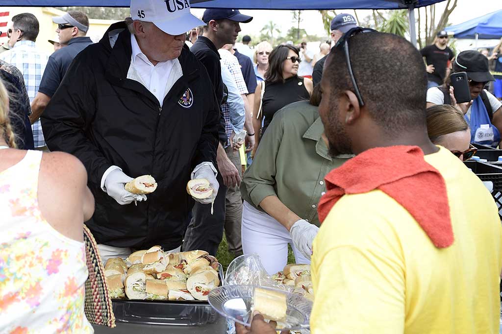 Trump turut membagikan makanan kepada para korban badai Irma.