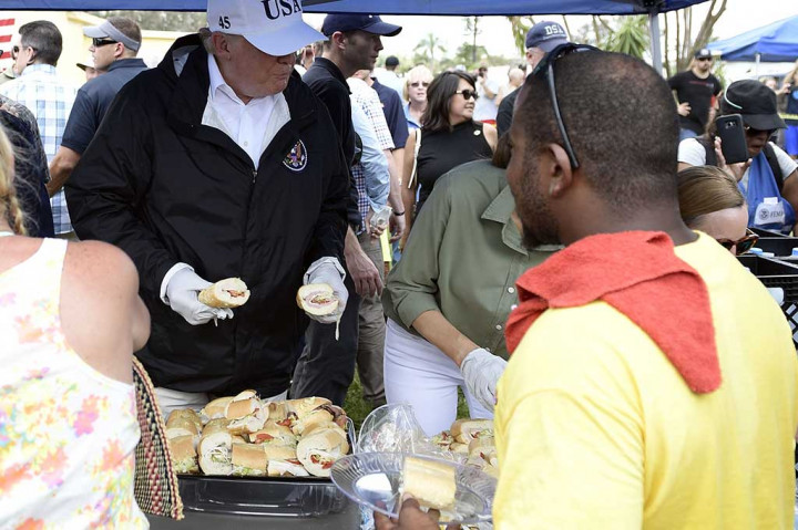 Trump turut membagikan makanan kepada para korban badai Irma.