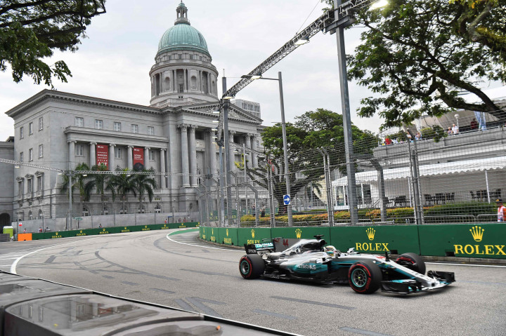 Mobil balap Mercedes yang dipacu Lewis Hamilton dalam babak kualifikasi di sirkuit Marina Bay, Singapura.