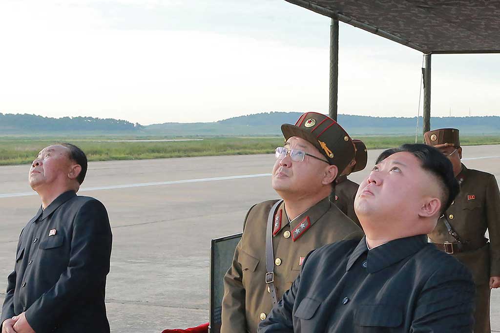 Gambar yang dirilis kantor berita resmi Korea Utara KCNA, Sabtu (16/9/2017), menunjukkan pemimpin Korut Kim Jong-Un (kanan) tengah menyaksikan peluncuran roket balistik strategis jangka menengah Hwasong-12 di lokasi yang tidak diungkapkan.