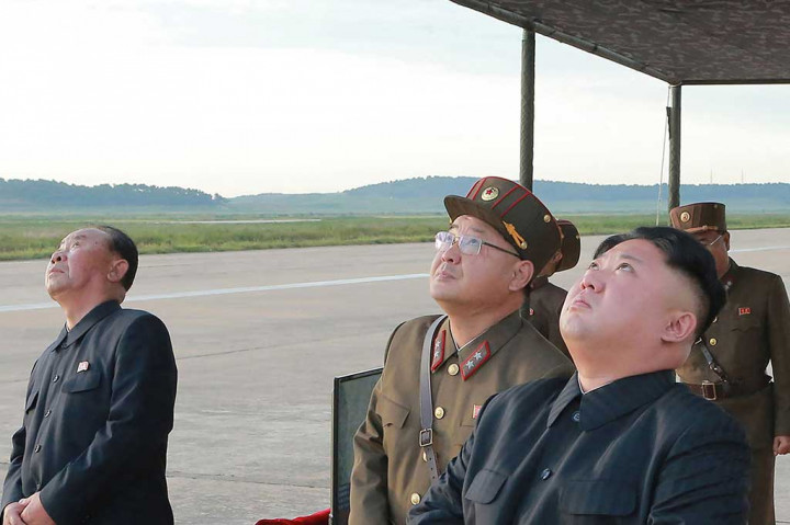 Gambar yang dirilis kantor berita resmi Korea Utara KCNA, Sabtu (16/9/2017), menunjukkan pemimpin Korut Kim Jong-Un (kanan) tengah menyaksikan peluncuran roket balistik strategis jangka menengah Hwasong-12 di lokasi yang tidak diungkapkan.