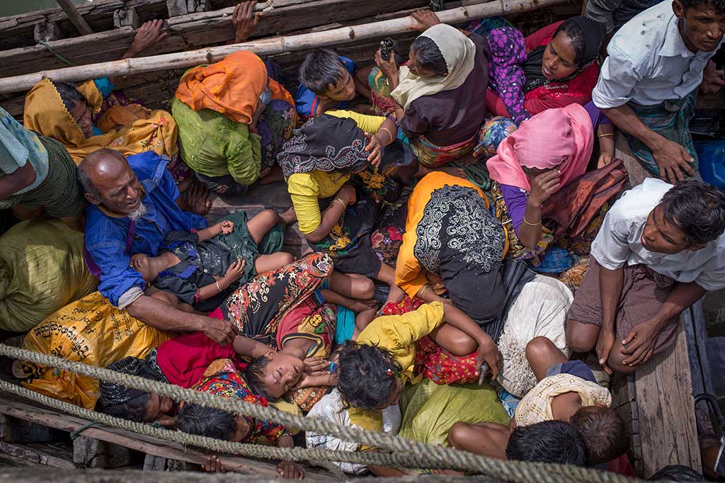 Para pengungsi Rohingya saling bertumpukan di sebuah kapal saat tiba di Shah Parir Dwip, sisi Sungai Naf, Bangladesh, 12 September lalu. Ribuan warga Rohingya menyeberang menuju Bangladesh akibat kekerasan dan pembakaran perkampungan mereka. AFP/Adib Chowdhury