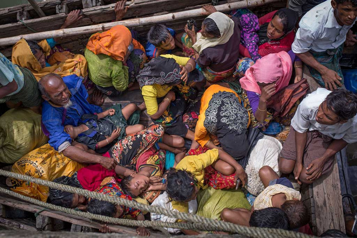Para pengungsi Rohingya saling bertumpukan di sebuah kapal saat tiba di Shah Parir Dwip, sisi Sungai Naf, Bangladesh, 12 September lalu. Ribuan warga Rohingya menyeberang menuju Bangladesh akibat kekerasan dan pembakaran perkampungan mereka. AFP/Adib Chowdhury