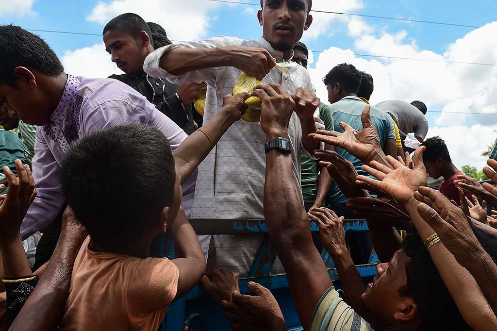 Para pengungsi Rohingya saling berebut makanan yang dibagikan dari atas truk di Ukhia, 14 September lalu. Kondisi sekitar 389 ribu warga Rohingya yang menyelamatkan diri dari pembantaian oleh militer Myanmar di Rakhine saat ini sangat memprihatinkan. AFP/Munir Uz Zaman