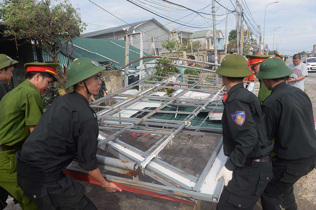 Tentara dan polisi bahu-membahu memperbaiki rumah-rumah penduduk yang rusak disapu topan Doksuri di Kota Anh Ky, Provinsi Ha Tinh.