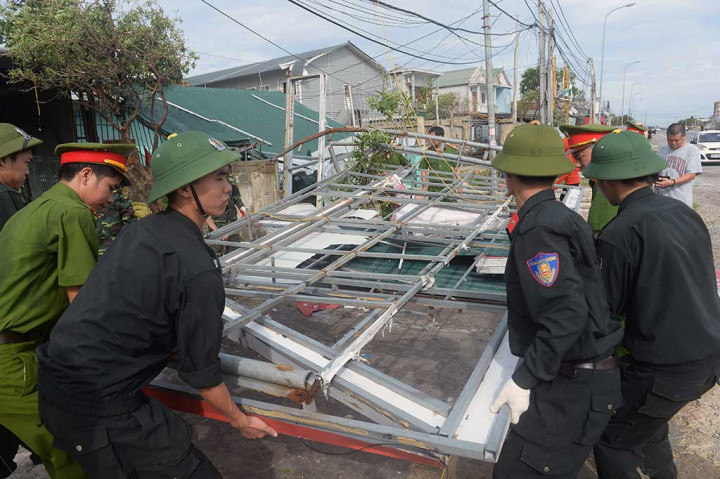 Tentara dan polisi bahu-membahu memperbaiki rumah-rumah penduduk yang rusak disapu topan Doksuri di Kota Anh Ky, Provinsi Ha Tinh.