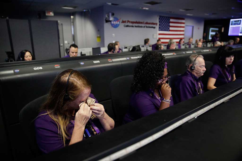 Seorang insinyur tim Cassini (kiri) menyeka air matanya dalam kendali misi di Jet Propulsion Laboratory Pasadena, setelah konfirmasi kematian pesawat ruang angkasa tersebut.