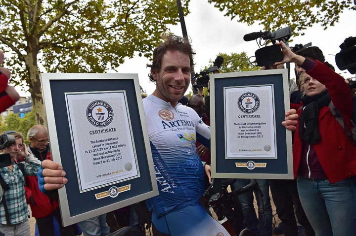 Pembalap sepeda Inggris Mark Beaumont berpose dengan sertifikat Guinness World Records saat tiba di Arc de Triomphe, Paris, Senin (18/9/2017), setelah menyelesaikan tur keliling dunia dalam waktu 78 hari.