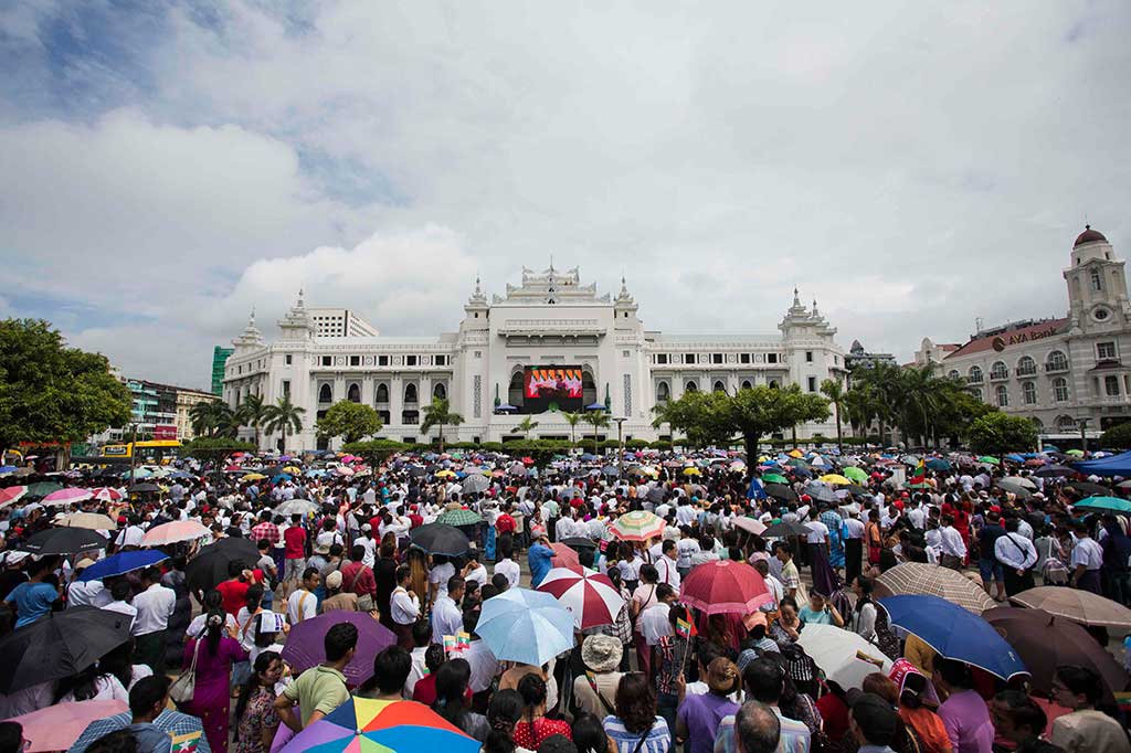 Warga berkumpul untuk mendengarkan pidato langsung Penasihat Myanmar Aung San Suu Kyi di depan Balai Kota di Yangon. 