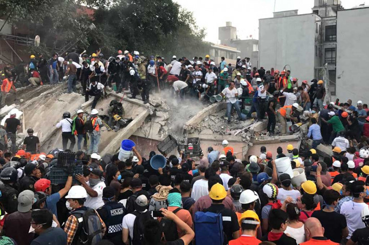Para petugas penyelamat dibantu warga dengan penuh kepanikan terus berupaya mencari orang-orang yang kemungkinan masih hidup di bawah reruntuhan di Mexico City,Selasa (19/9/2017).