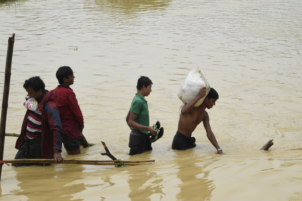 Seorang pengungsi berusaha menyelamatkan logistik bantuan  dari tendanya yang kebanjiran. Logistik bantuan tersebut baru diterimanya beberapa hari sebelumnya.