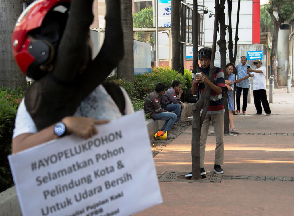 Aksi kampanye #AyoPelukPohon berlangsung di trotoar Jl MH Thamrin, Jakarta, Jumat (22/9/2017)