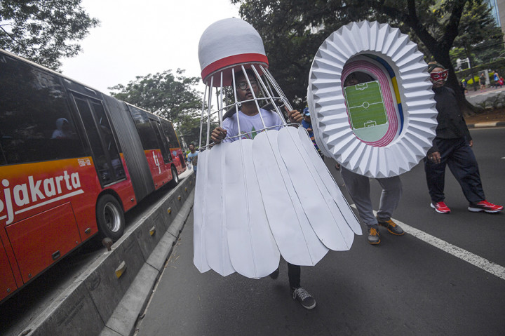Peserta dengan kostum kok dan miniatur Stadion Utama Gelora Bung Karno mengikuti Karnaval Gelora Bung Karno di Jalan Jenderal Sudirman, Senayan, Jakarta.