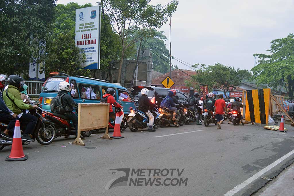 Pengguna jalan hanya bisa melewati satu lajur untuk dua arah bergantian, karena separuh jembatan sudah mulai dihancurkan.