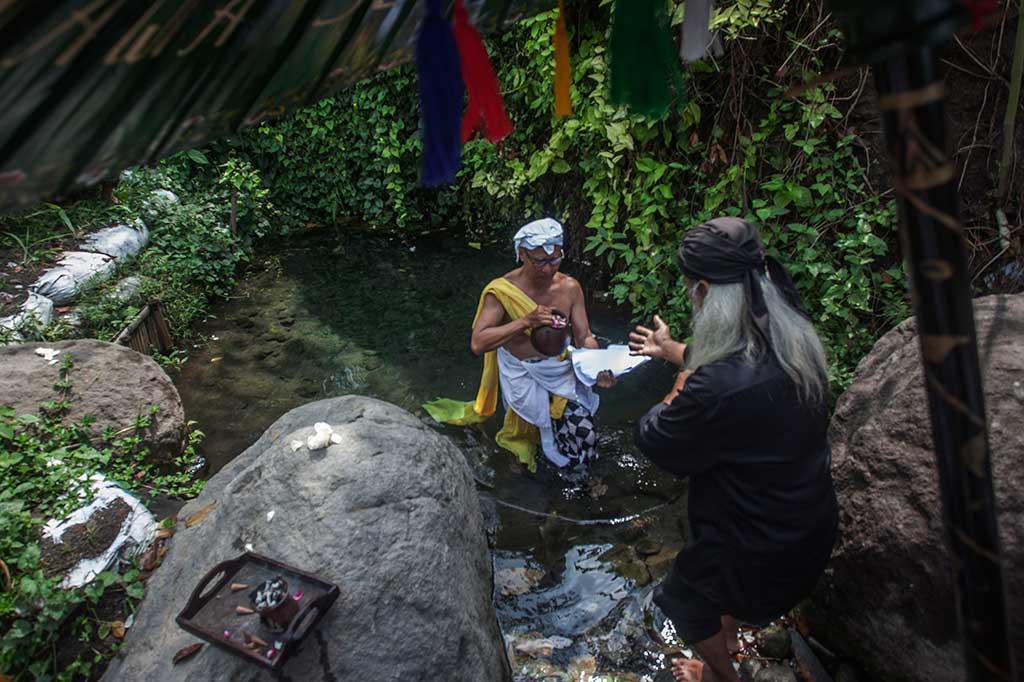 Warga melakukan ritual pemgambilan air saat acara Merti Kali di Kali Kuning, Sempu, Wedomartani, Sleman.