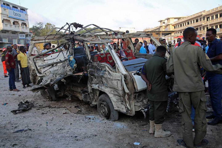 Petugas berada di dekat sebuah mobil yang hancur dihantam bom di dekat Pasar Hamarweyne, Mogadishu, Somalia, Kamis (28/9/2017) waktu setempat.