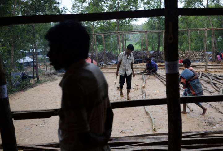Beberapa pria memperbaiki tenda pengungsian tempat tinggal mereka. Tingginya curah hujan beberapa pekan terakhir membuat banyak tenda rusak dan kebanjiran.