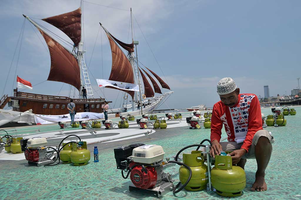 Seorang nelayan penerima bantuan mencoba memasang konverter kit pada tabung khusus LPG pada pemberian paket perdana konversi BBM ke BBG di Anjungan Losari, Makassar.