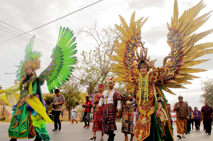 Dua pelajar mengenakan pakaian dengan motif burung Garuda pada prade penutupan FLS2N di Kupang, NTT, Jumat (29/9/2017). Parade yang diikuti seluruh peserta FLS2N tersebut menampilkan sejumlah pakaian adat masing-masing daerah dengan maksud menunjukkan betapa beragamnya suku dan budaya Indonesia.