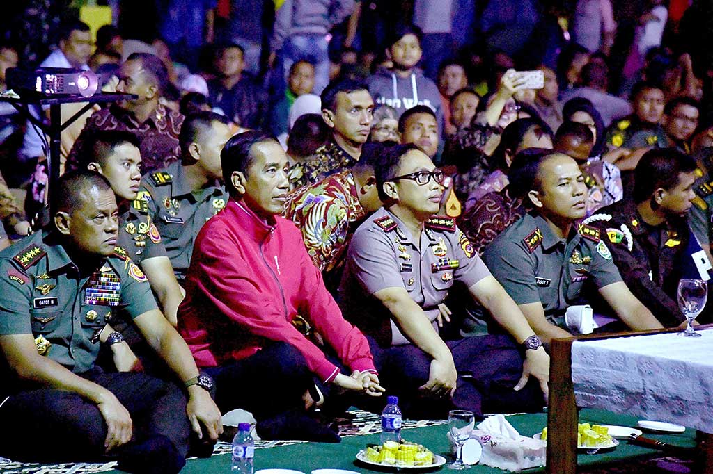 Presiden Joko Widodo didampingi Panglima TNI Jenderal Gatot Nurmantyo (kiri) dan sejumlah jajaran perwira dan prajurit TNI dan Polri beserta masyarakat menonton film 'Pengkhianatan G30S/PKI' di Makorem 061/Suryakencana Bogor, Jumat (29/9) malam.