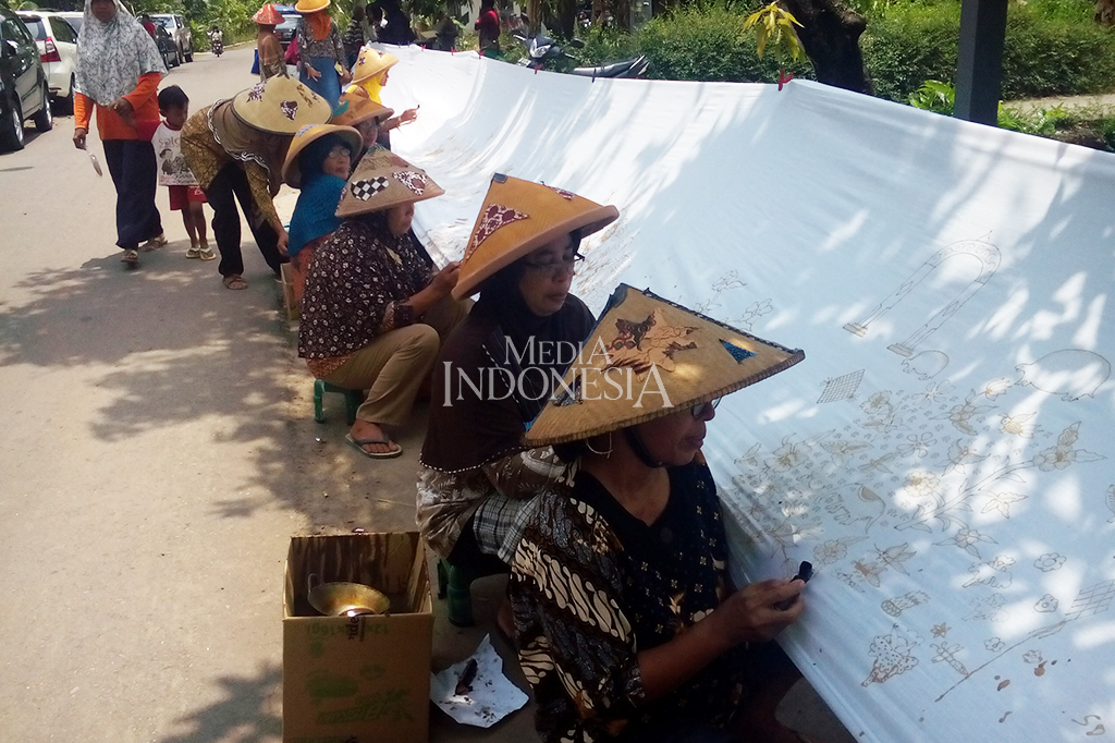 Ratusan perajin batik, masyarakat umum, dan pelajar membantik di atas kantin sepanjang 208 meter di Desa Kebon, Kecamatan Bayat, Kabupaten Klaten, Jawa Tengah. Kegiatan tersebut dalam rangka peringatan Hari Batik Nasional 2017. MI/Djoko Sardjono