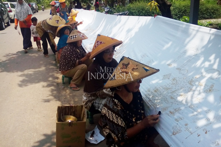 Ratusan perajin batik, masyarakat umum, dan pelajar membantik di atas kantin sepanjang 208 meter di Desa Kebon, Kecamatan Bayat, Kabupaten Klaten, Jawa Tengah. Kegiatan tersebut dalam rangka peringatan Hari Batik Nasional 2017. MI/Djoko Sardjono
