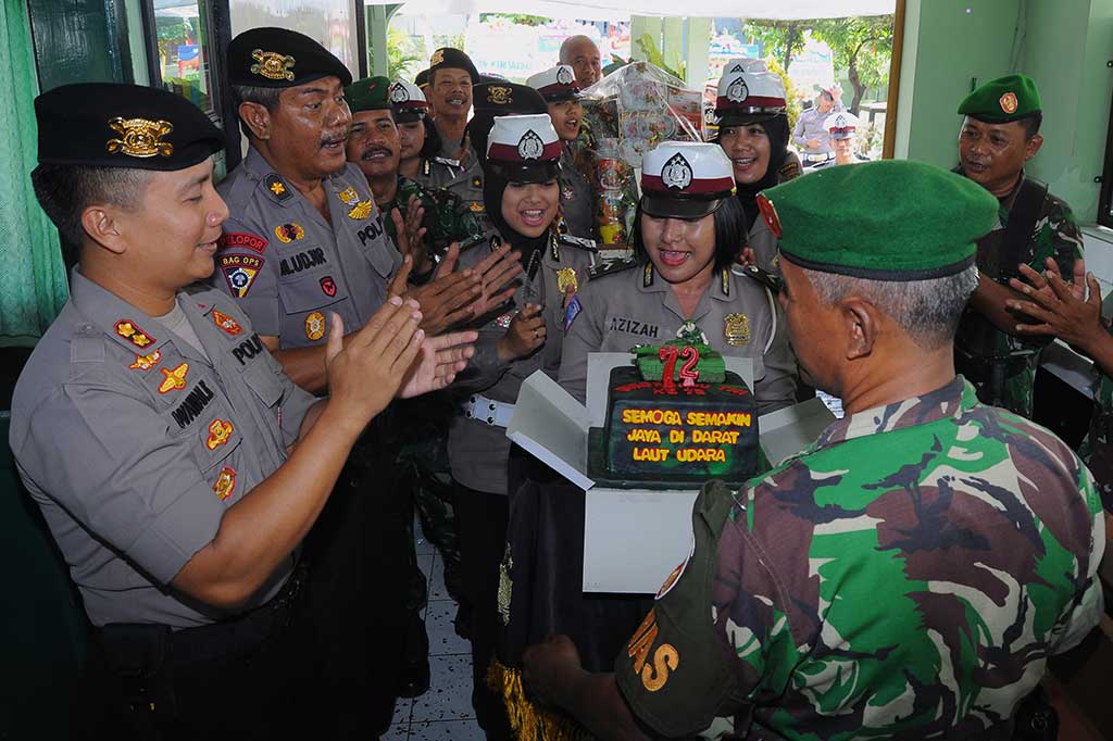 Kapolres Pekalongan AKBP Wawan Kurniawan (kiri) beserta anggota memberikan kue ulang tahun kepada anggota TNI saat peringatan HUT ke-72 TNI di kantor Kodim 0710 Pekalongan, Jawa Tengah. ANTARA/Harviyan Perdana Putra