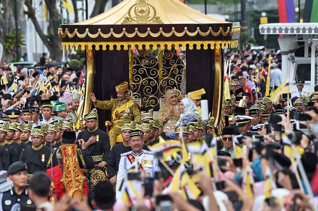 Sultan Brunei Darussalam Sultan Hassanal Bolkiah dan Ratu Saleha naik kereta kencana yang dilapis emas, melambaikan tangan kepada warga saat menggelar peringatan 50 tahun naik takhta, di Bandar Seri Begawan, Kamis (5/10/2017).