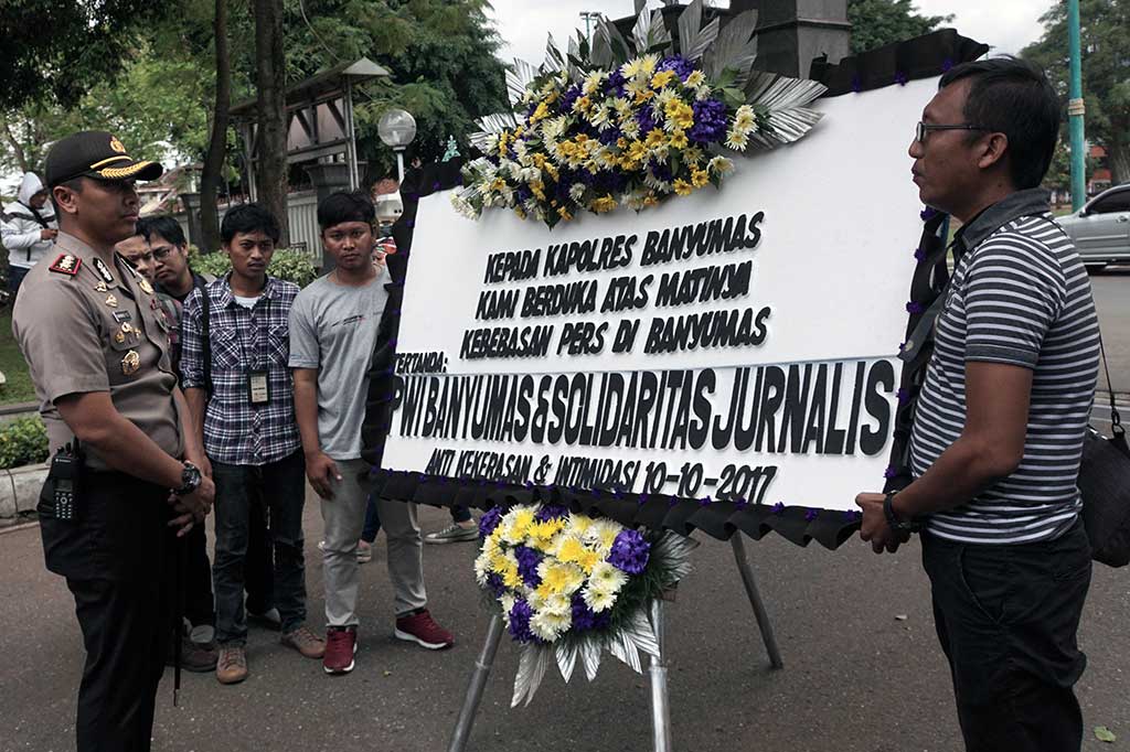 Sejumlah jurnalis menyerahkan karangan bunga duka cita kepada Kapolres Banyumas AKB Bambang Yudhantara Salamun (kiri) saat melakukan aksi unjuk rasa di Pendopo Bupati Banyumas, Jawa Tengah, Selasa (10/10/2017). ANTARA/Idhad Zakaria