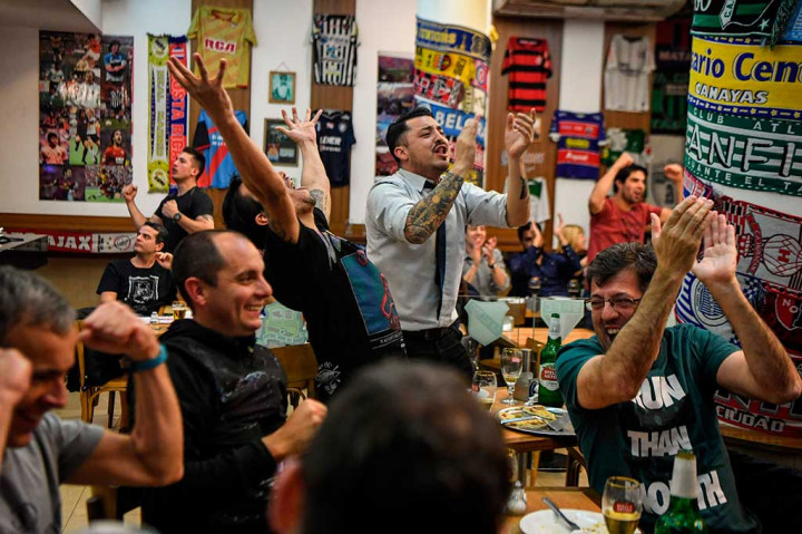 Keberhasilan Argentina melaju ke Piala Dunia 2018 disambut suka cita warga yang menonton lewat televisi di Buenos Aires. AFP/Eitan Abramovich