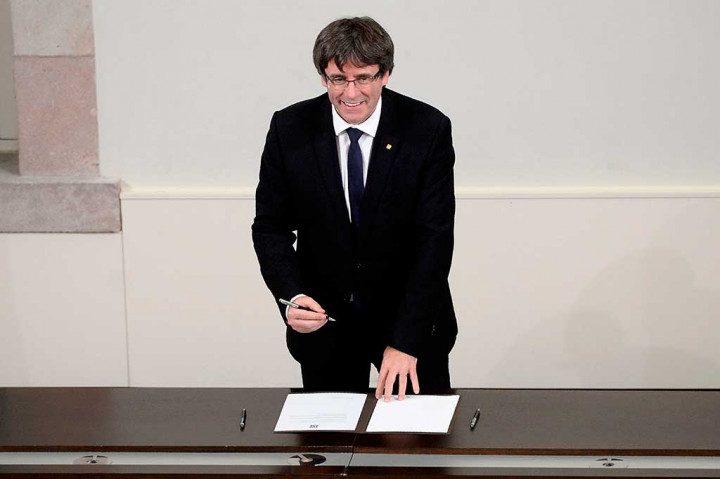 Carles Puigdemont menandatangani dokumen tentang kemerdekaan Catalunya di parlemen daerah Catalan, Barcelona, Selasa (10/10/2017) waktu setempat. AFP/Josep Lago